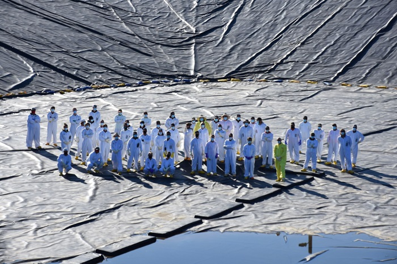 A field crew poses for a team photo after replacing the cover of a 7.8-million-gallon wastewater basin at Hanford’s Liquid Effluent Retention Facility. Four of the large basins will support tank waste treatment operations under the Direct-Feed Low-Activity Waste Program.