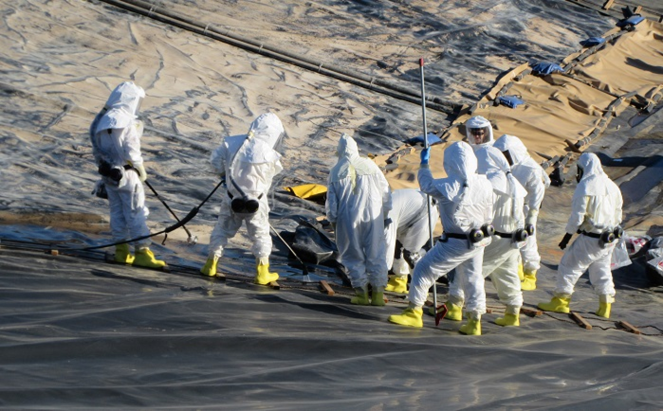Workers use a special tool to cut the old cover on Basin 44 at Hanford’s Liquid Effluent Retention Facility, allowing for installation of the new cover. The floating cover was replaced because of age-related deterioration.
