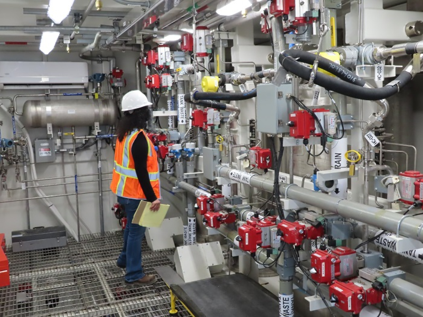 Nitya Chandran, a facility engineer with the Washington State Department of Ecology, inspects the Tank-Side Cesium Removal connections as a part of the Direct-Feed Low-Activity Waste system at the Hanford Site.