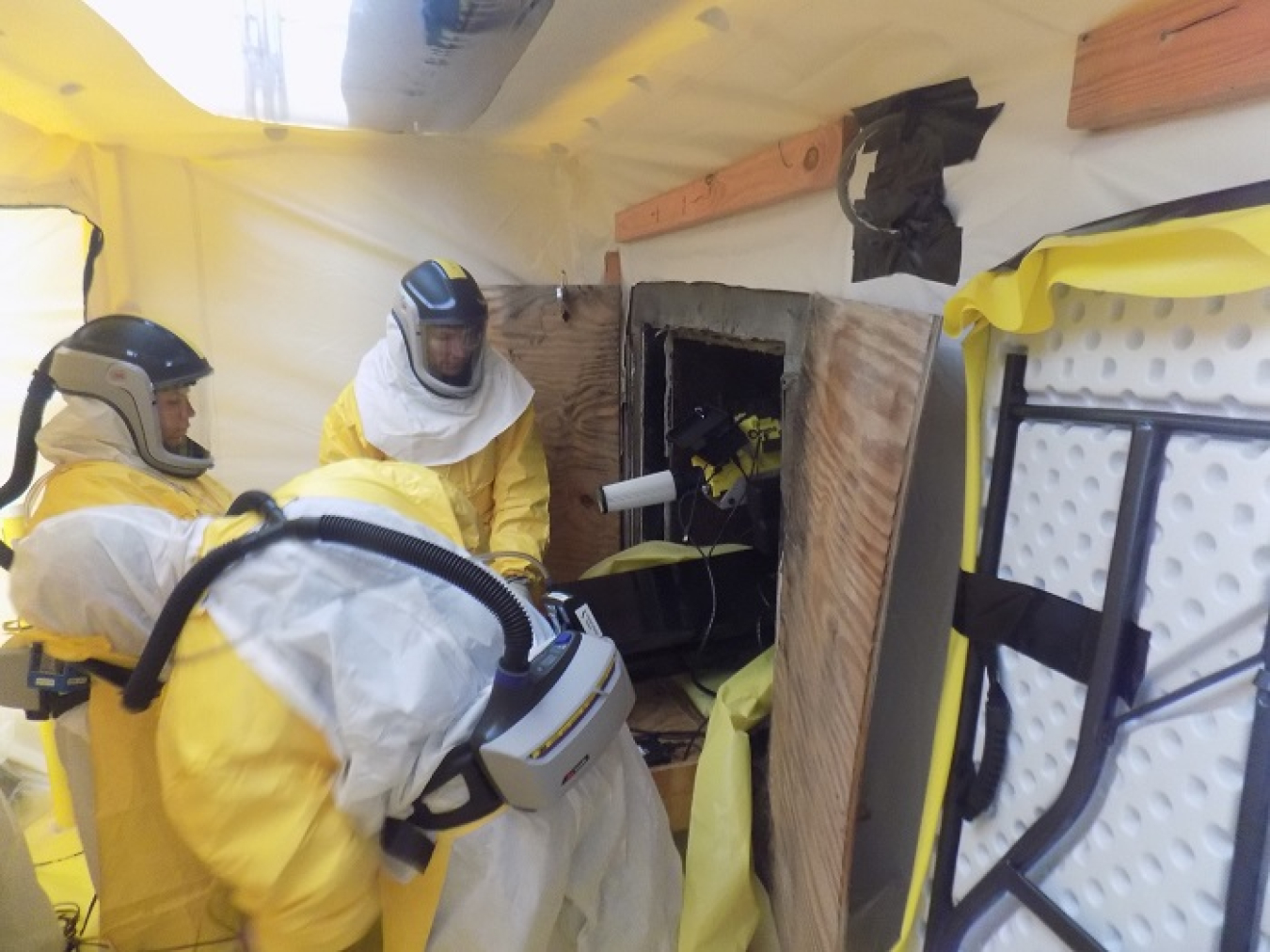 A crew moves a high-tech imaging camera into the final remaining hot cell at the former Radioisotope Development Laboratory at Oak Ridge National Laboratory. The detector overlays a radiation-intensity color-map on a picture of the environment to show nuclides and their locations.