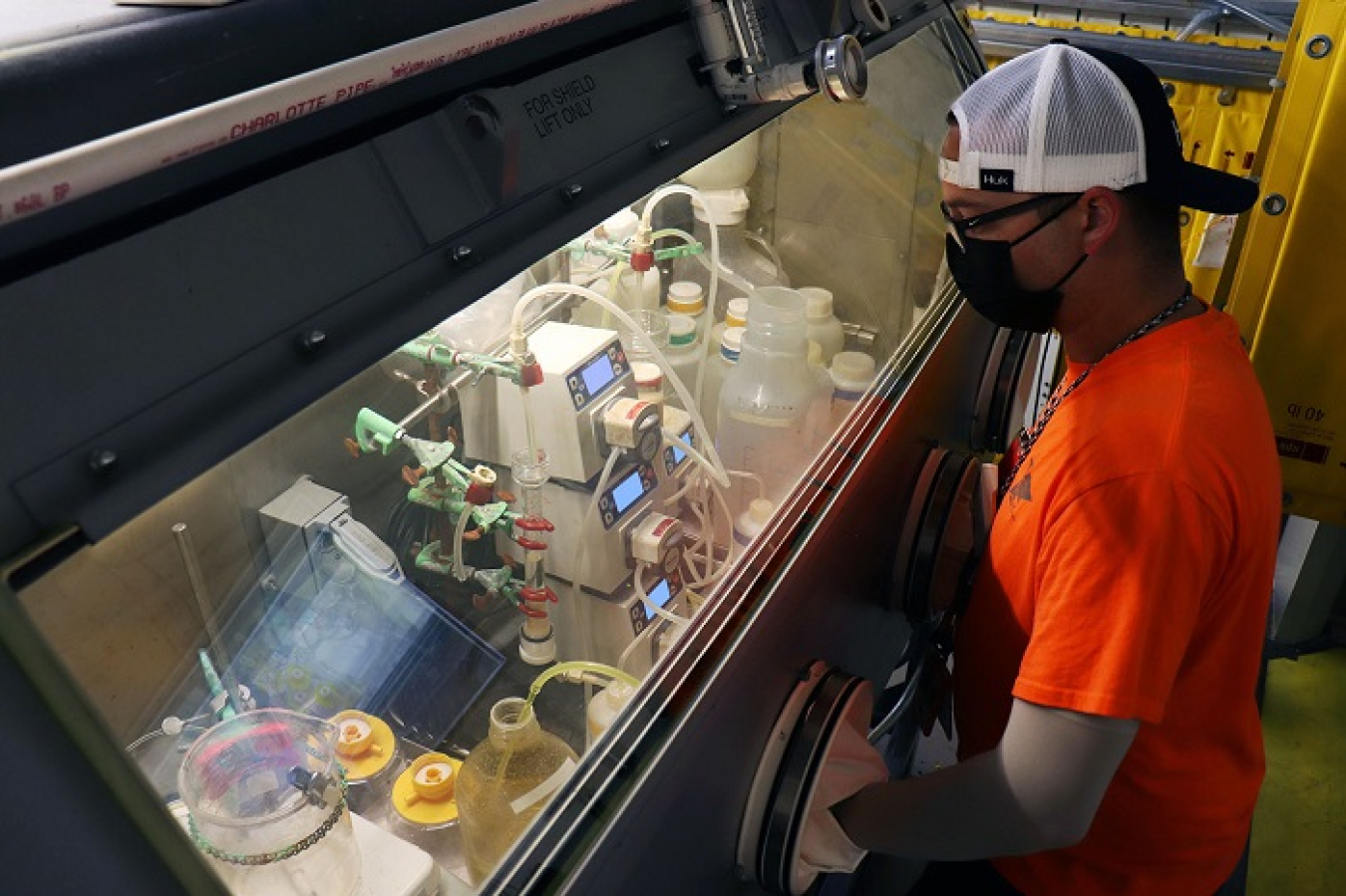 An Isotek employee processes low-dose uranium-233 material in a glovebox at Oak Ridge National Laboratory. Processing the material prepares it for safe transportation and disposal, and allows for the extraction of thorium to support next-generation cancer treatment research.