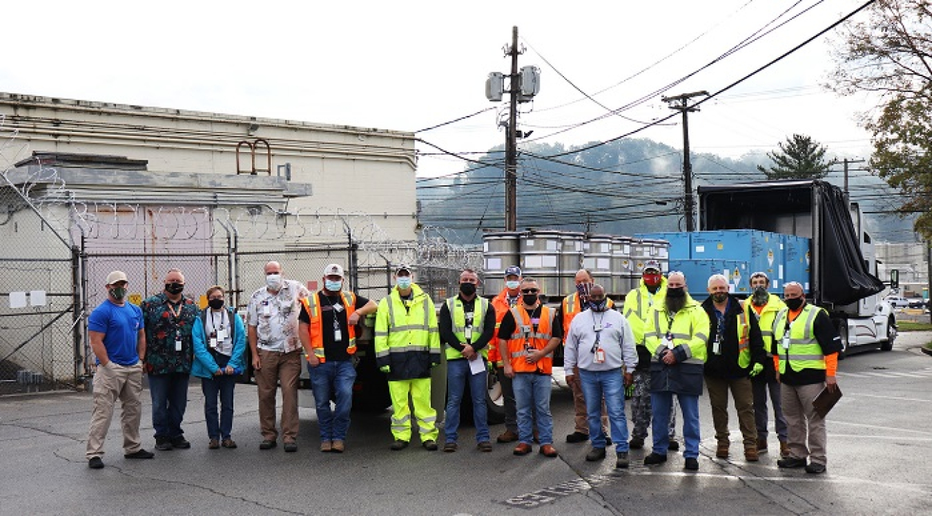 Employees with Oak Ridge Office of Environmental Management contractor Isotek gather in front of drums containing the final low-dose uranium (U)-233 material they processed for disposal. Isotek finished processing and disposing that portion of the U-233 inventory stored at Oak Ridge National Laboratory this month.