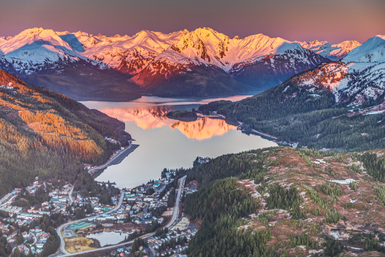 Aerial view of a lake and mountains with snow. 