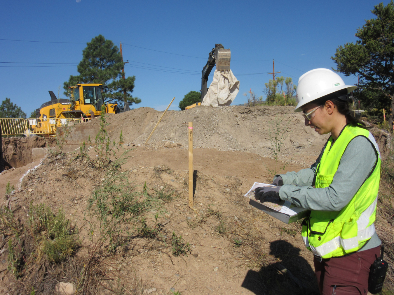 A geologist for EM-LA’s cleanup contractor Newport News Nuclear BWXT-Los Alamos assesses excavation of contaminated soil near one of LANL’s Cold War-era underground explosives firing chambers in Lower Water Canyon.