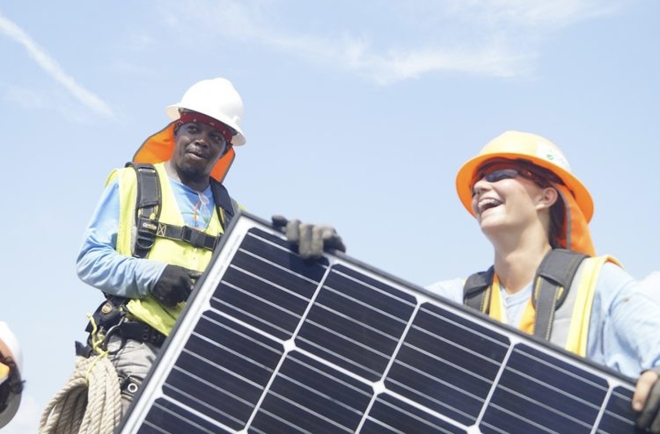 Kaly Moore and a colleague holding a solar panel.