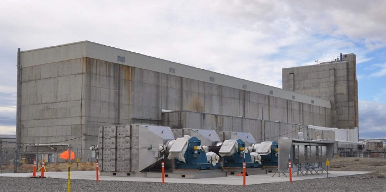 Three new exhauster units are anchored on a concrete pad and ready for connection to the Hanford Site’s Reduction-Oxidation Plant. When connected, the exhausters will improve airflow and filtration to protect workers as they continue to prepare the contaminated facility for demolition.