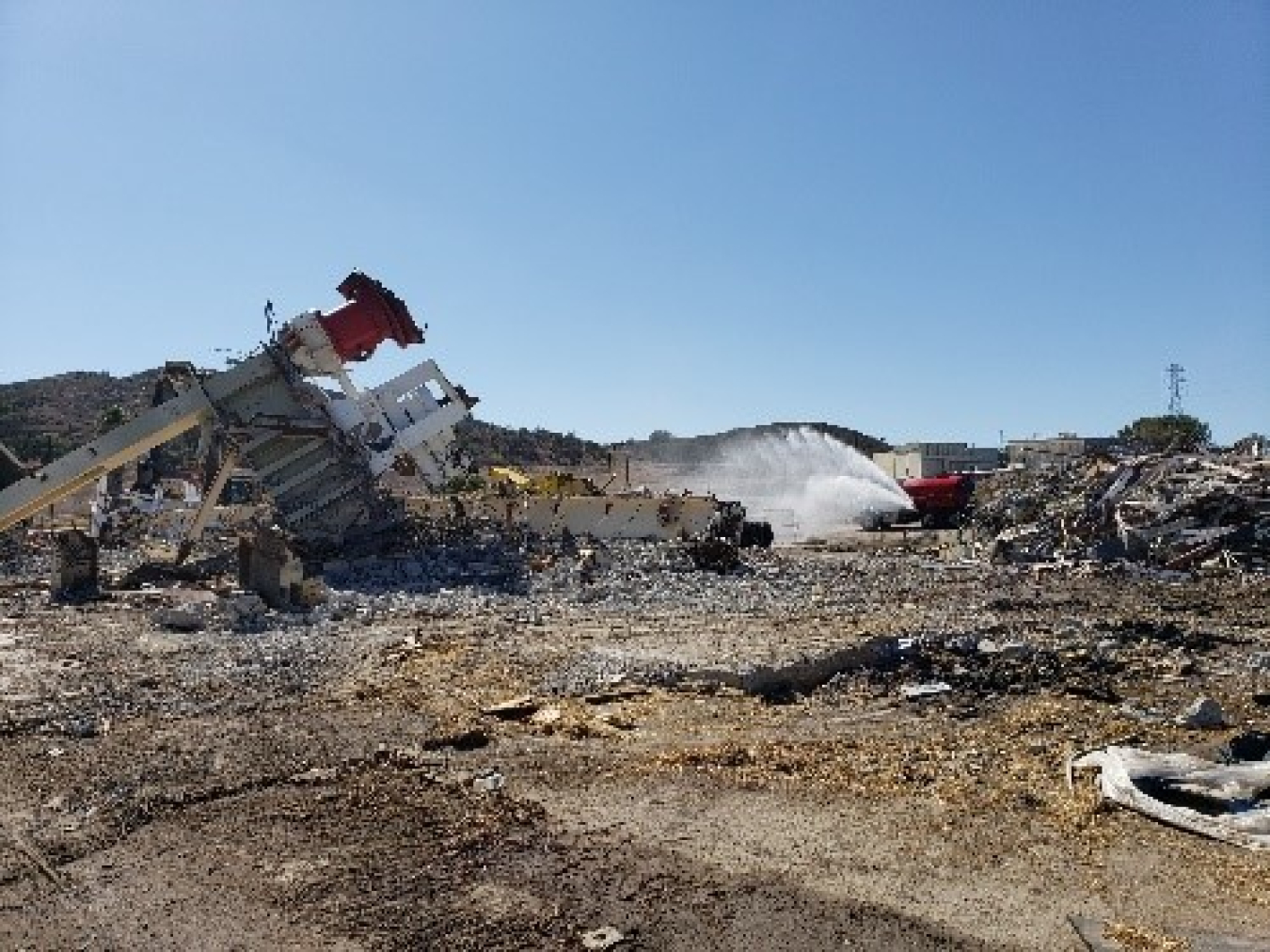 Water is applied for dust suppression following demolition of the Sodium Pump Test Facility. Before demolition, workers also extensively pre-wetted the structure and the surrounding area to control dust.