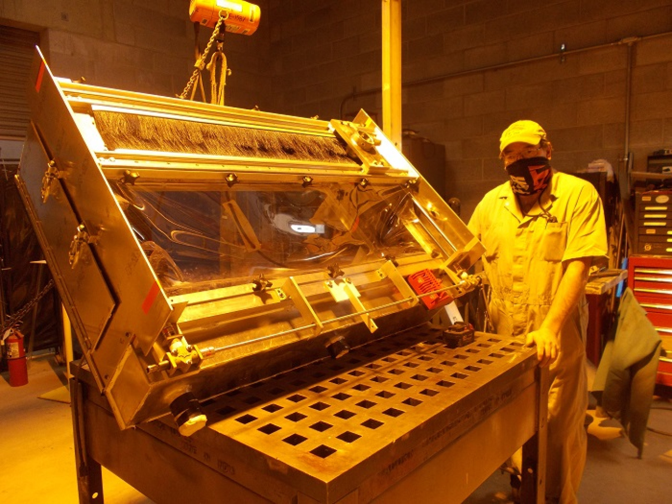 Mark Hebdon, a maintenance mechanic and fabricator with CH2M HILL BWXT West Valley, stands next to a containment box that was modified to incorporate employee feedback for improved safety, productivity, and efficiency. 