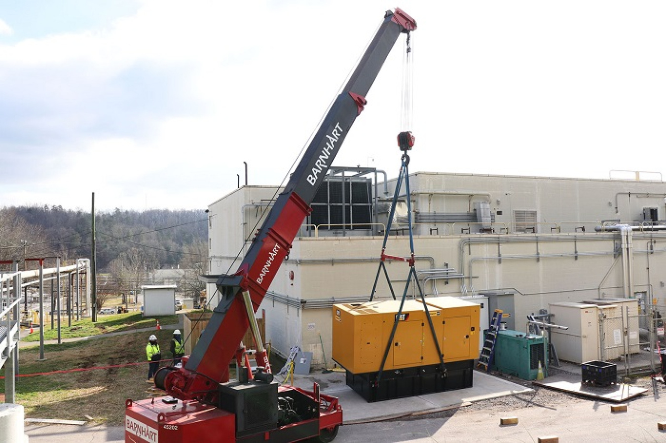 Workers install a backup diesel generator at Building 2026. If there is a loss of power, it can produce enough power to maintain operation of equipment necessary to process uranium-233 at Oak Ridge.