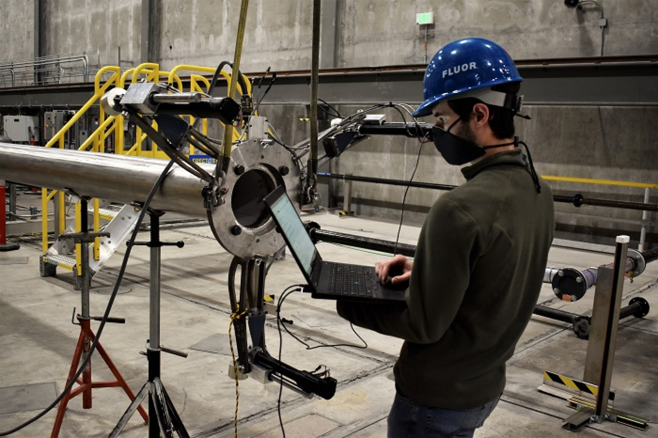 Christopher Graham, calcine retrieval project lead design engineer for EM contractor Fluor Idaho, adjusts settings on an access riser positioning system.