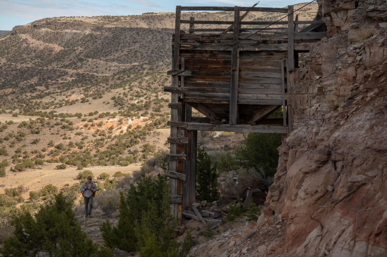 A staff member from Bat Conservation International walks below a wooden ore bin in New Mexico. (Photo by Bill Hatcher/BCI.)