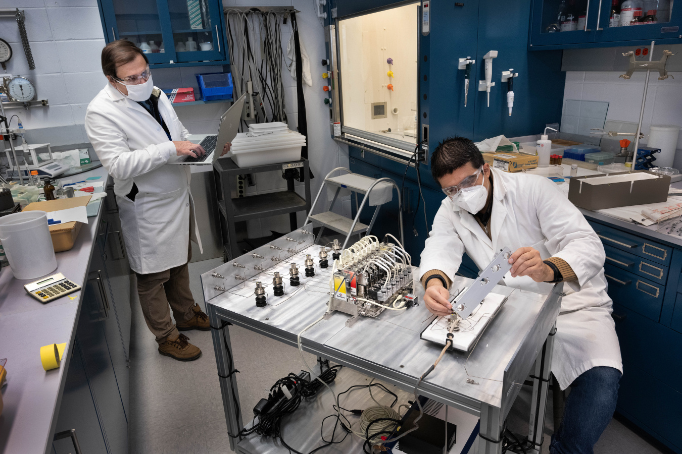 Brookhaven senior scientist Jose Rodriguez and postdoctoral research associate Jorge Moncada (foreground) test an apparatus to rapidly pulse reactive gases for time-resolved studies of catalysts.