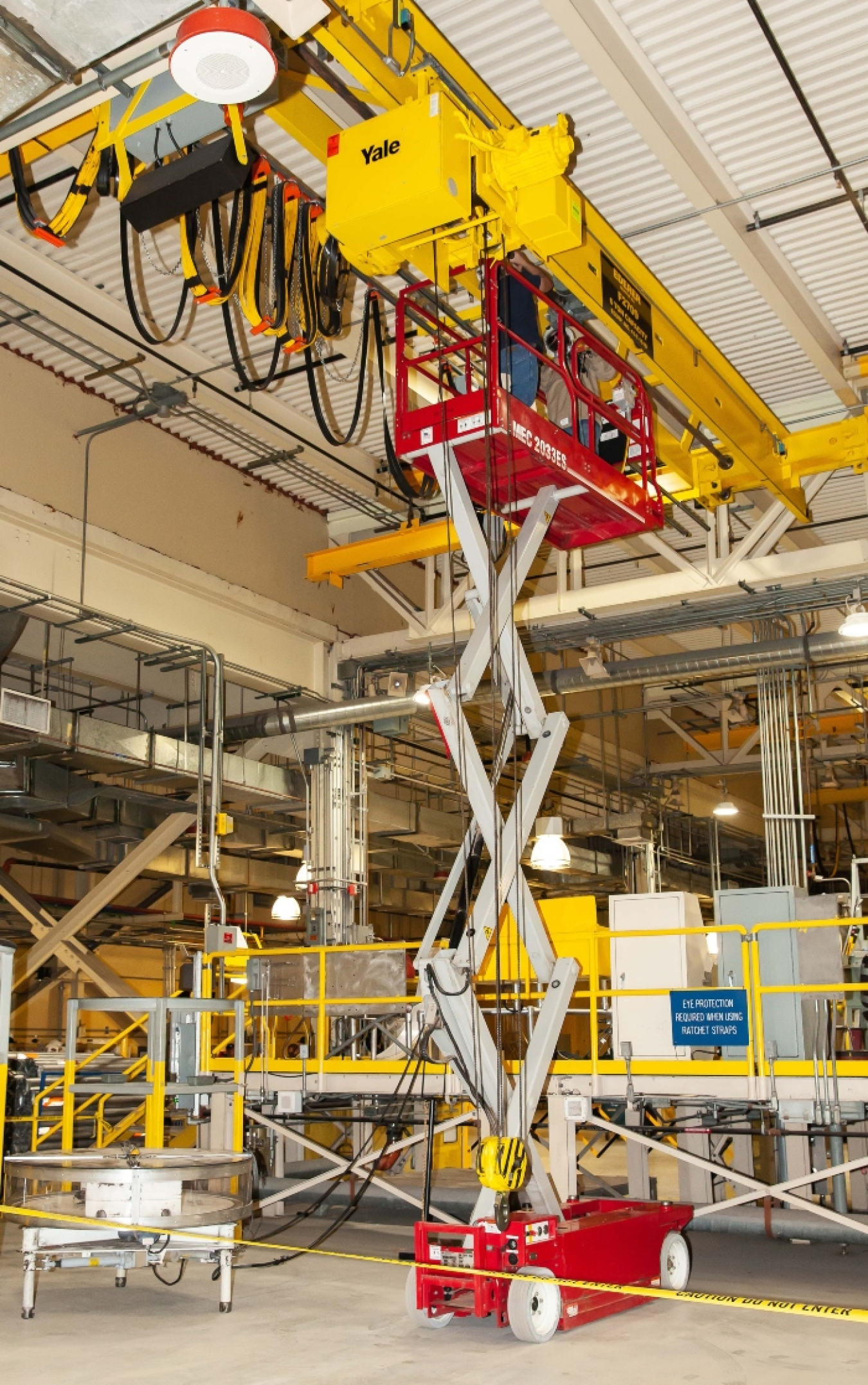 Waste Isolation Pilot Plant (WIPP) personnel perform maintenance on an overhead crane in the site’s Waste Handling Building. The crane is used to remove transuranic waste containers from transportation casks.