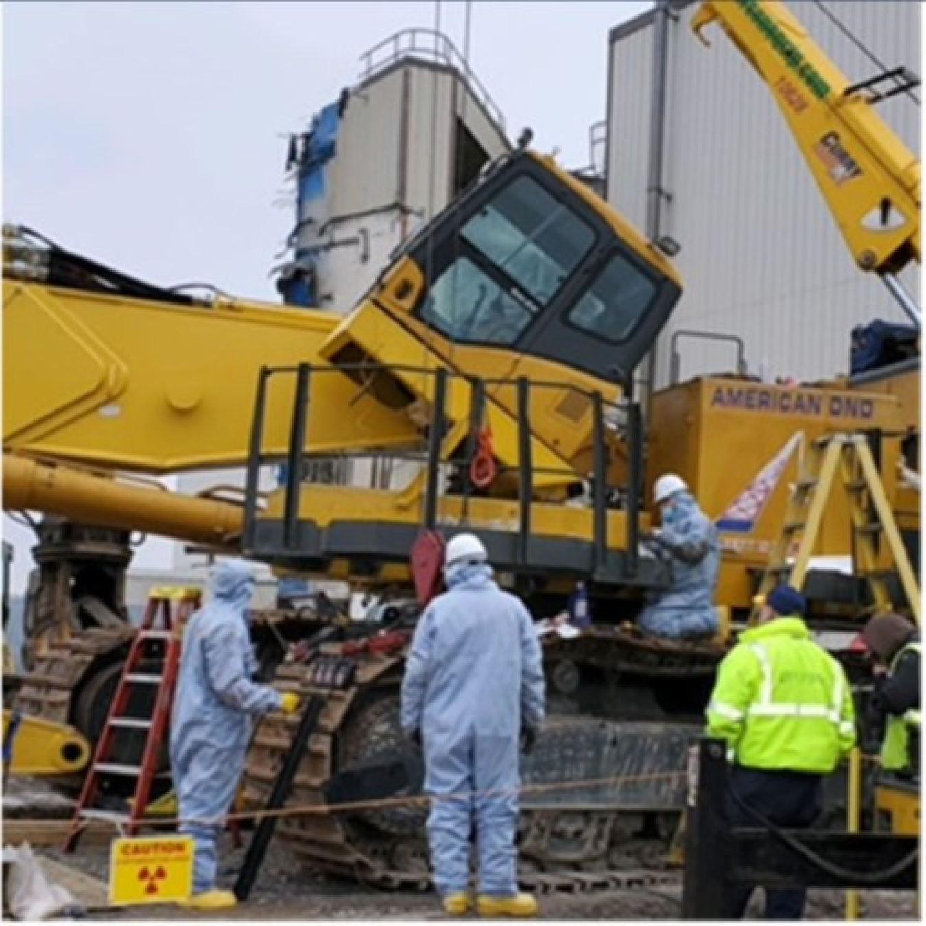 Crews install a new tilt cab in an excavator that will improve the operator’s view when performing high-reach work in the demolition of the Main Plant Process Building at the West Valley Demonstration Project.