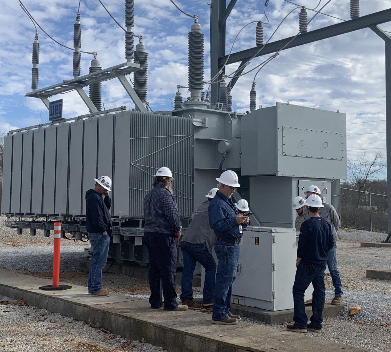 (L-R): Randall Shearer, Scott Sims, Curtis Hunt, Carlos Valencia, Todd Bolding, Ryan Smith, Matthew Perkins, and Russell Vinyard consult on settings of the new autotransformer.