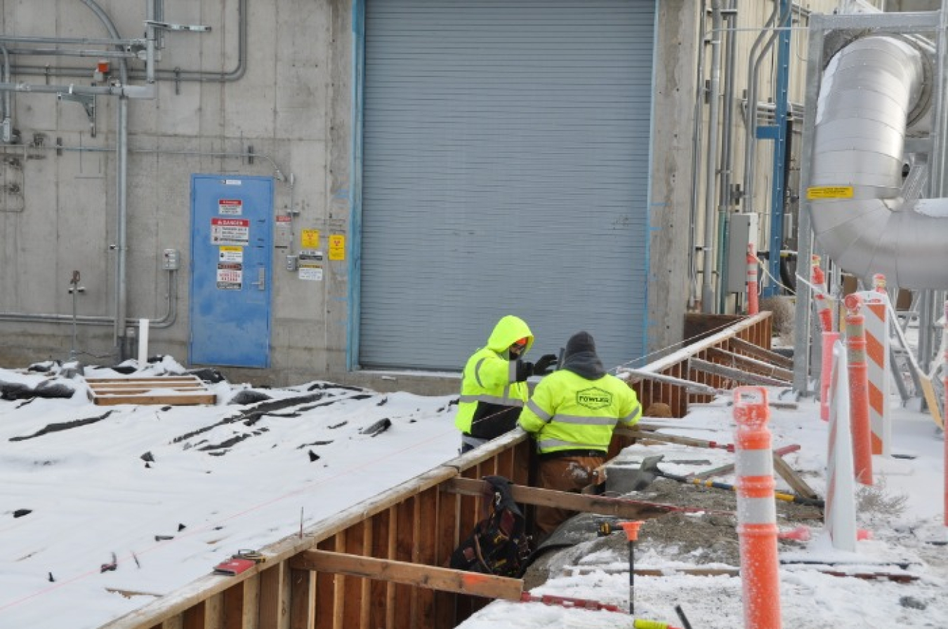 Jason Beaver and Pedro Ramirez with EM Richland Operations Office contractor Central Plateau Cleanup Company construct wooden forms for a new concrete pad outside the Waste Encapsulation and Storage Facility.