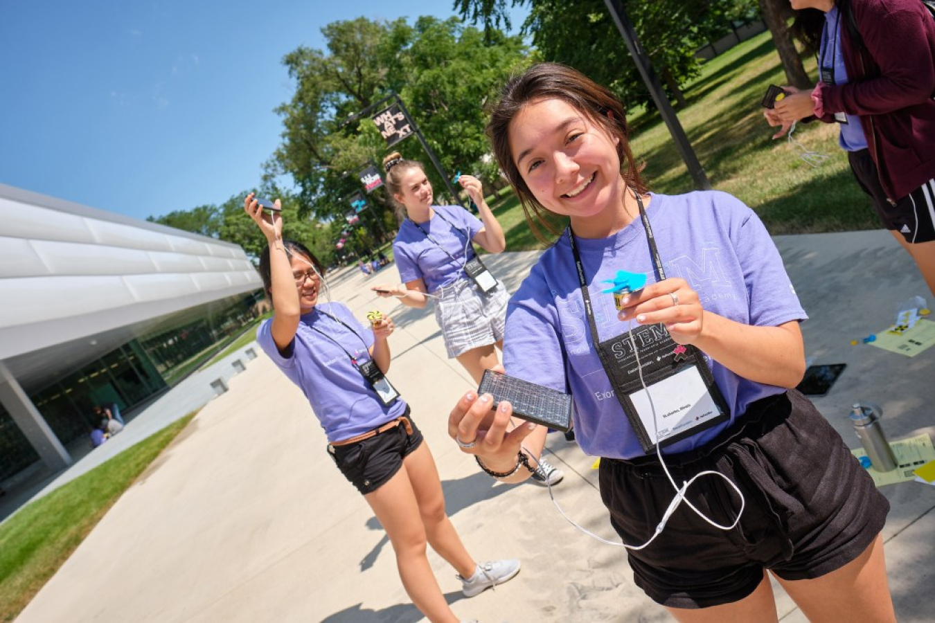 Three young women experiment with electrical devices.