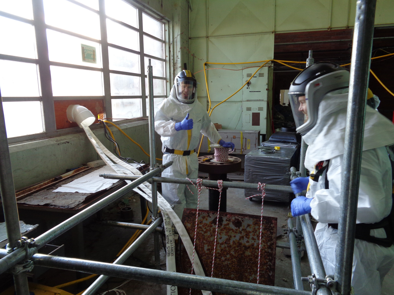 Workers pump water that accumulated in the Beta-1 facility’s basement at the Y-12 National Security Complex.