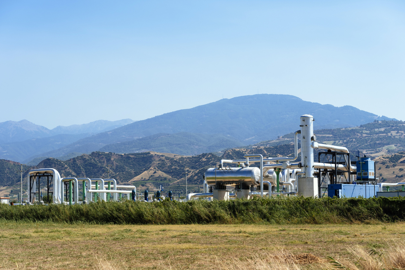Facility in the foreground, with green hilly background. 