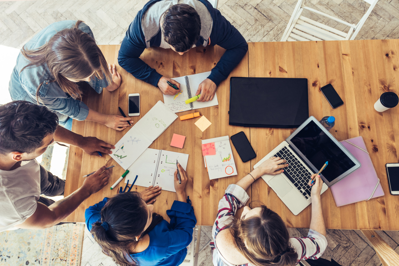 5 people around a table working on a project.