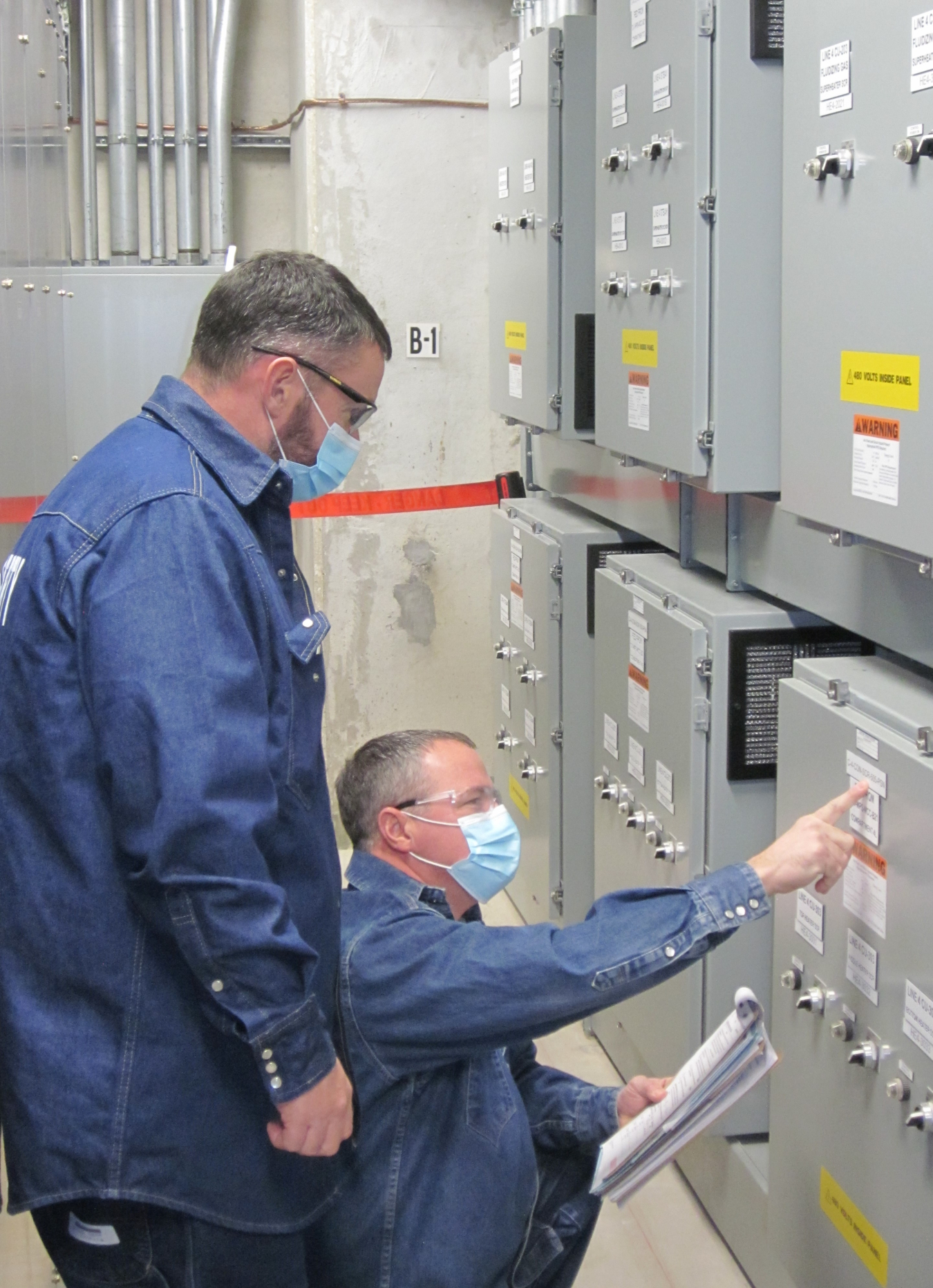 Photograph of two electricians performing work