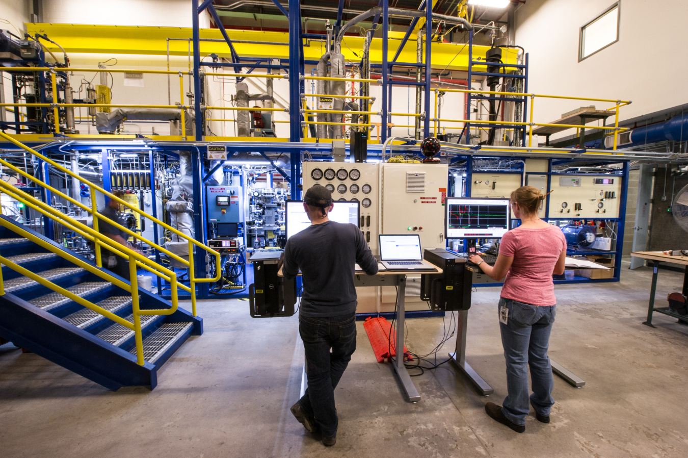 NREL engineers run product samples though NREL’s customizable Davison Circulating Riser reactor system. Image courtesy of Dennis Schroeder