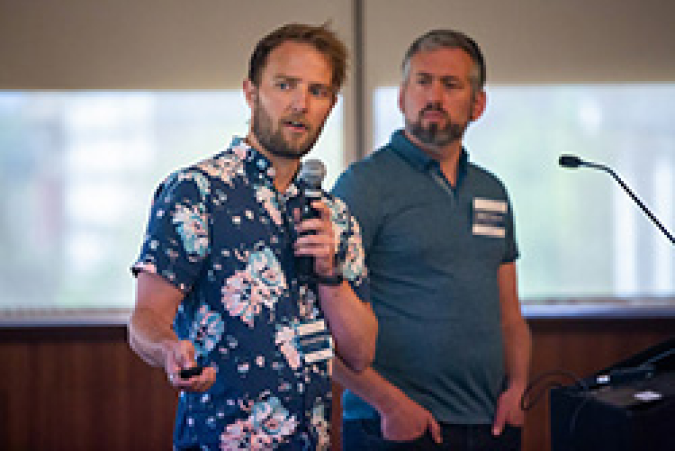 Two men presenting on stage.