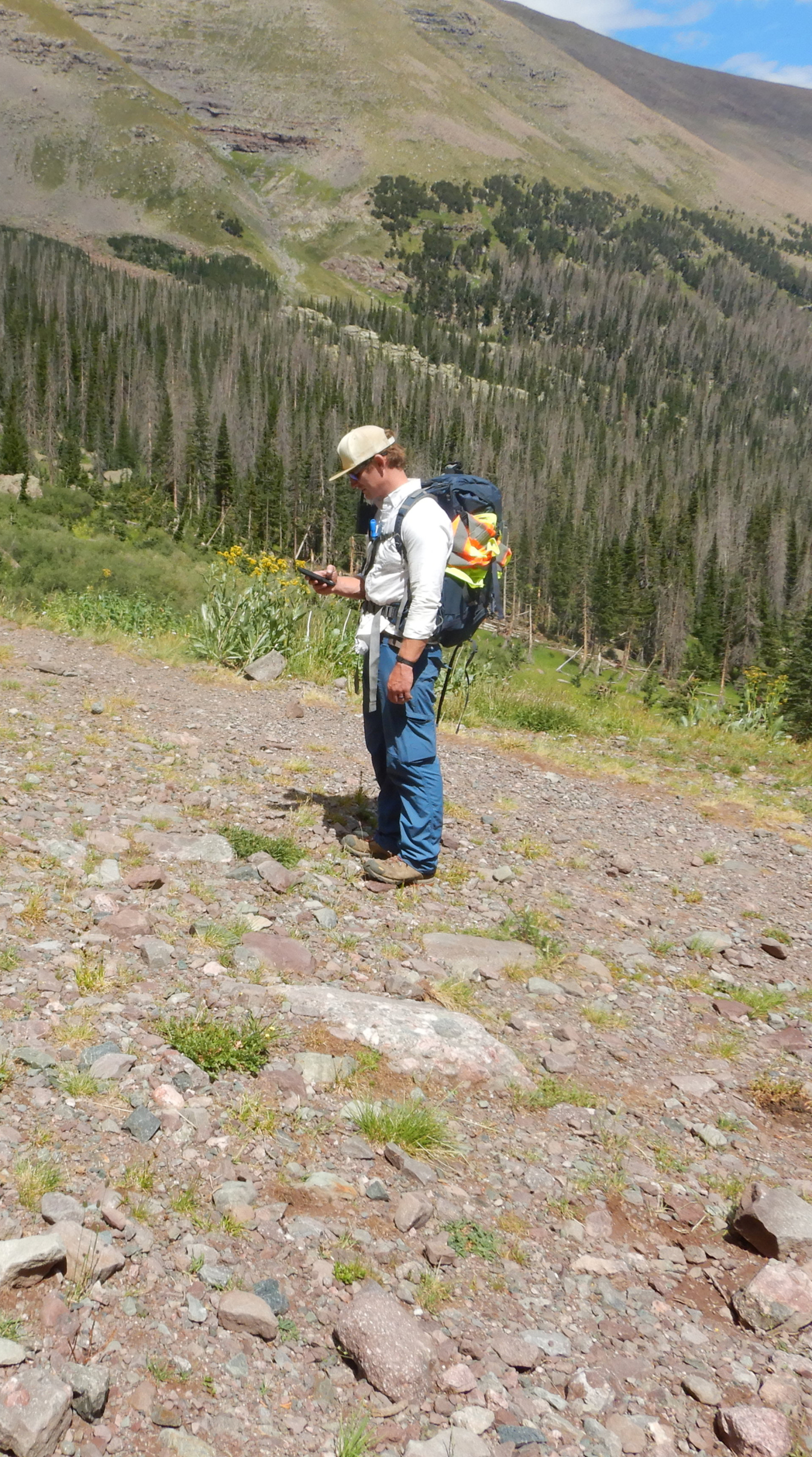 A DRUM team member surveying with a portable instrument for radiation detection and monitoring. Data and observations are used to perform risk rankings for each mine.