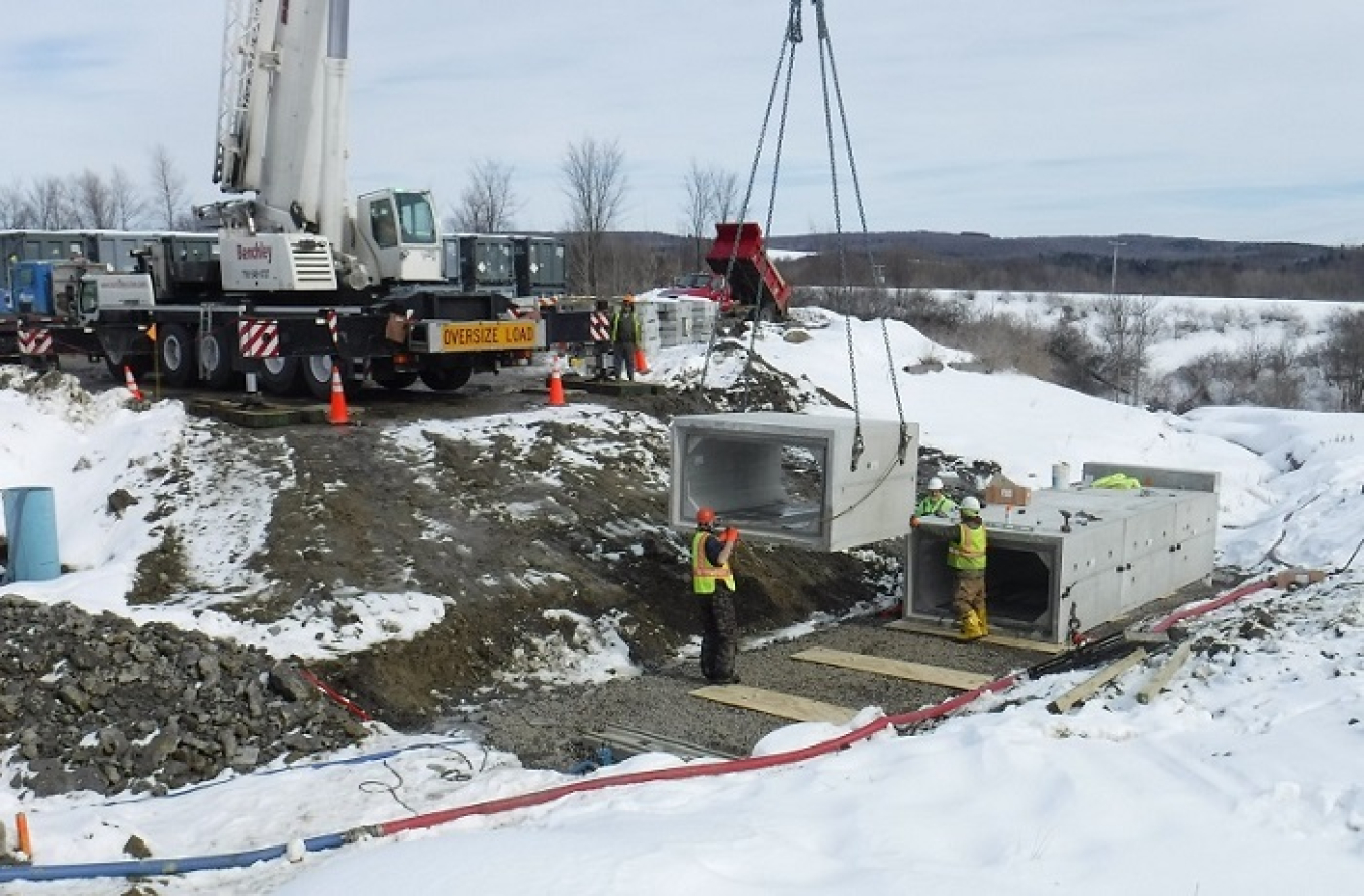 EM crews use a 235-ton crane to safely place concrete sections into position that will form a new culvert for a roadway at the West Valley Demonstration Project. Each section weighs an average of 16,000 pounds.