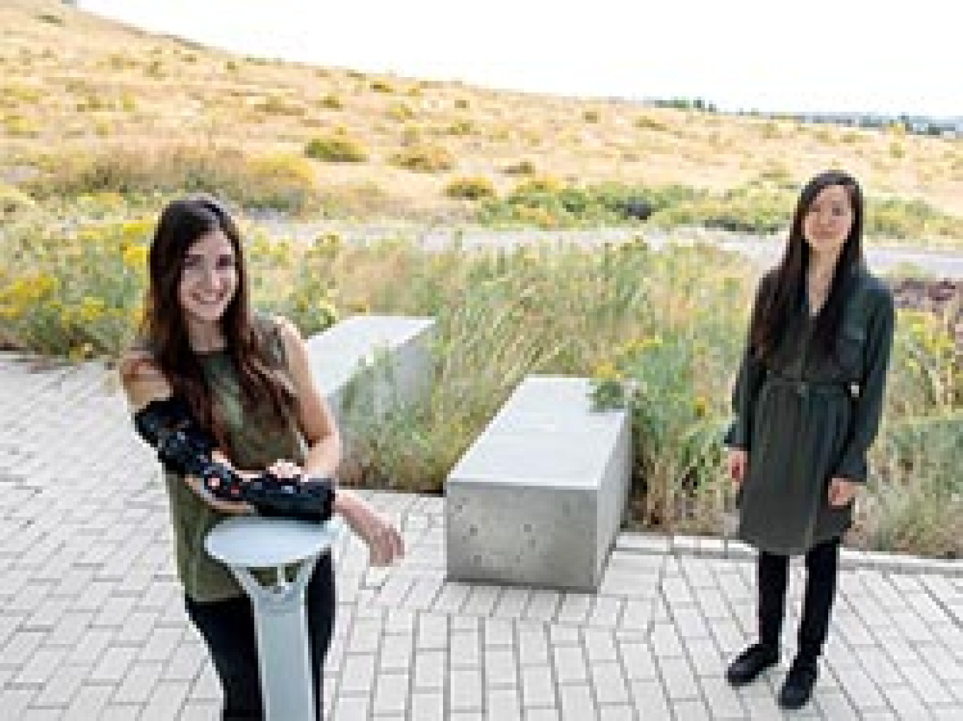 Two women smiling while standing outside.