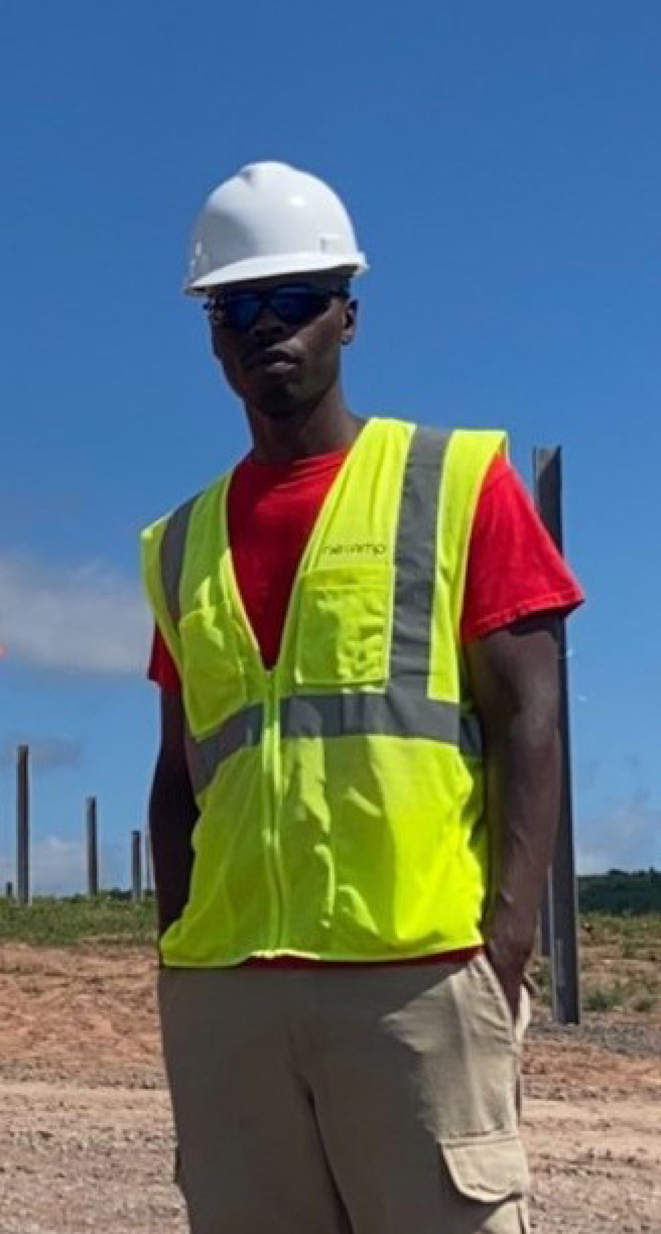 Conrad Flowers pictured in a field wearing hard had and safety vest.