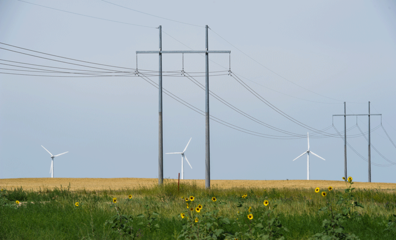 Electrical lines with wind turbines in the background.