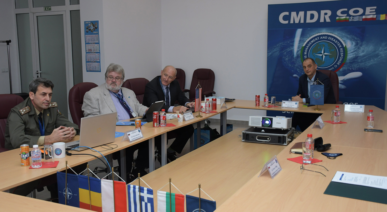 The Bulgarian and NNSA partners sitting at a table with flags on it.