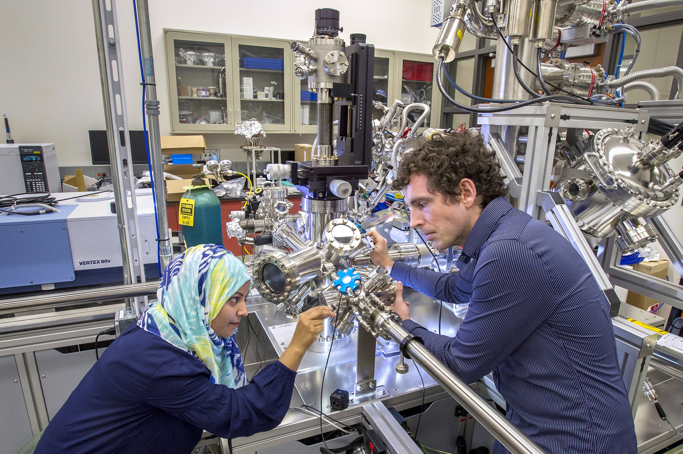 Scientists at the Center for Functional Nanomaterials at Brookhaven National Laboratory load a sample for in situ spectroscopy measurements. This state-of-the-art instrument allows for the study of chemical reactions at surfaces under elevated pressures through a combination of vibrational and photoelec¬tron spectroscopy.