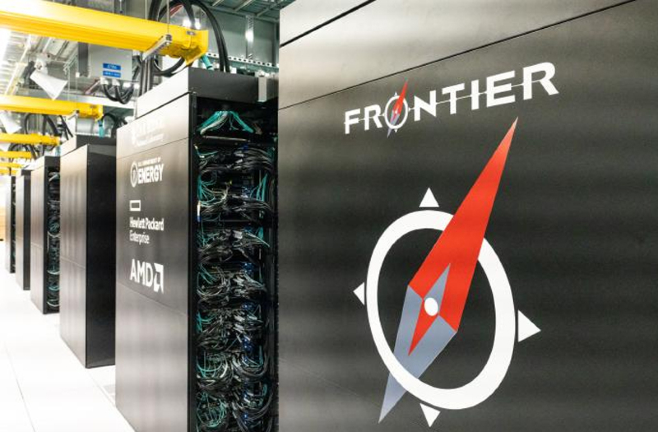 Rows of black computing cabinets with many wires and a red and white compass logo reading FRONTIER on the closest cabinet