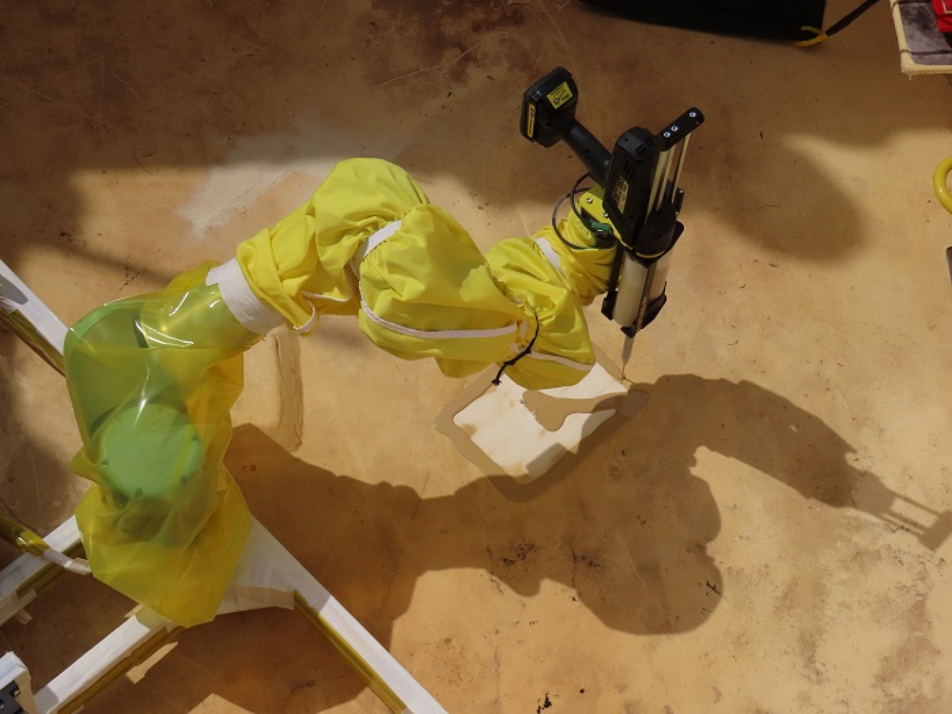 A robotic arm, deployed by EM contractor Washington River Protection Solutions workers, sands, repaints and applies a fresh waterproof coating to repair a valve pit’s torn liner at the Hanford Site.