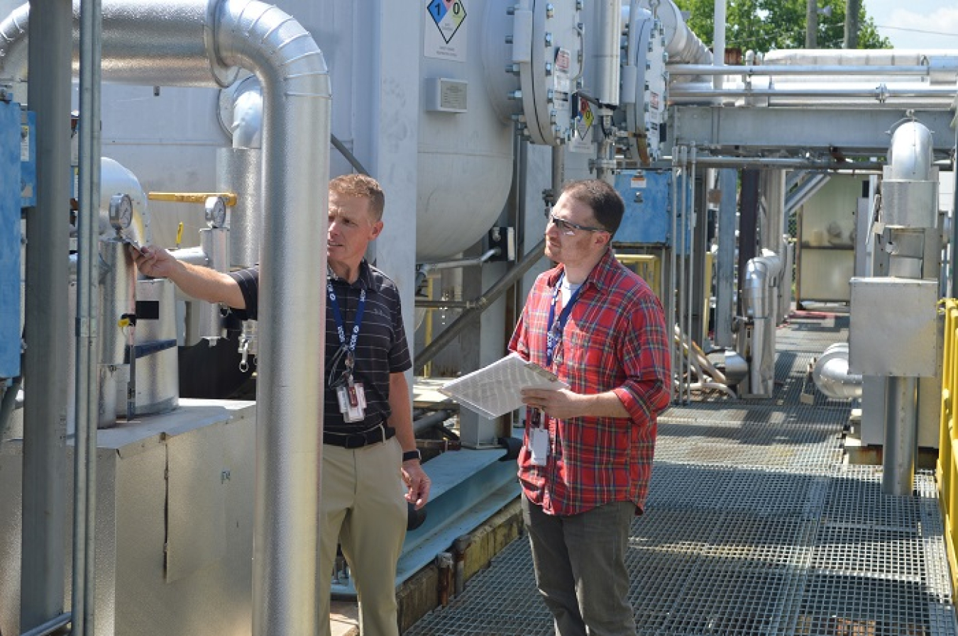 UCOR intern Frederic Harris, right, and Jason Jeansonne, process waste treatment engineer, are shown at the 3608 Process Waste Treatment Complex, where a large above-ground piping replacement job is underway.