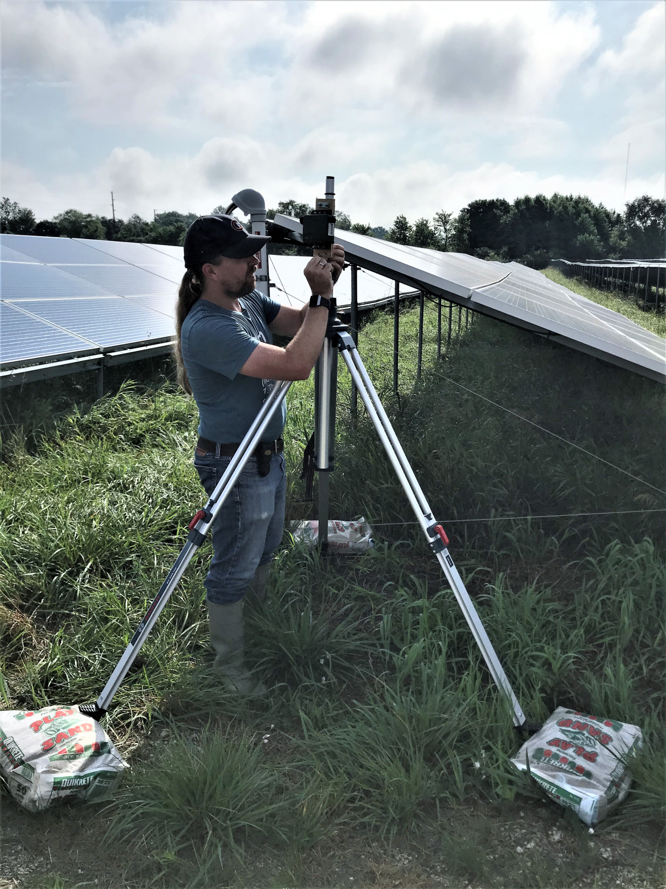 Lee Walston, an ecologist and team lead at Argonne National Laboratory, sets up acoustic and ultrasonic monitors and a motion-activated camera to evaluate wildlife activities at a solar facility collocated with pollinator habitat in Illinois.