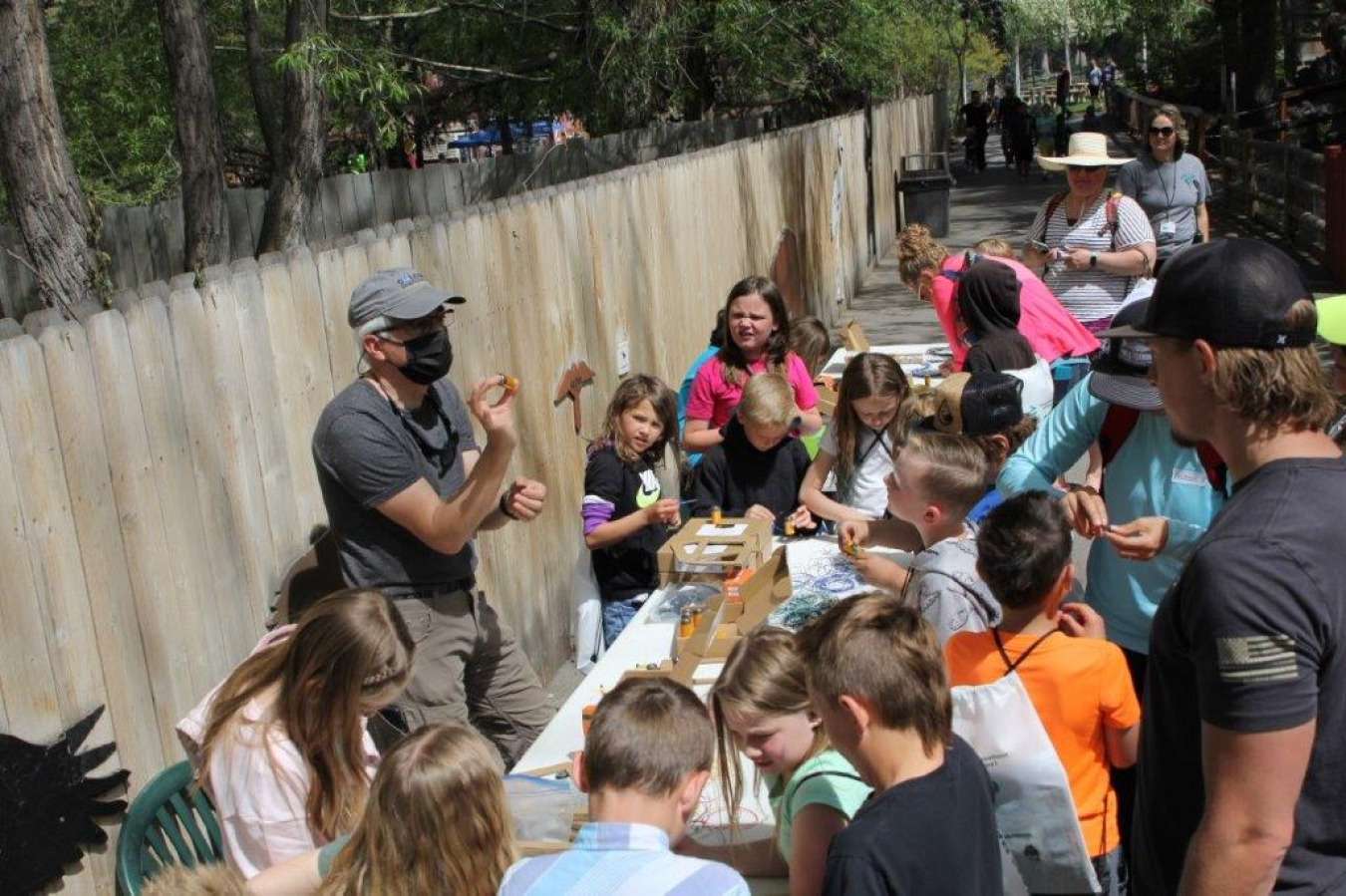 Kevin Young, an Idaho Environmental Coalition engineer, helps students build an electromagnet recently at STEAM Day at the Idaho Falls Zoo. 