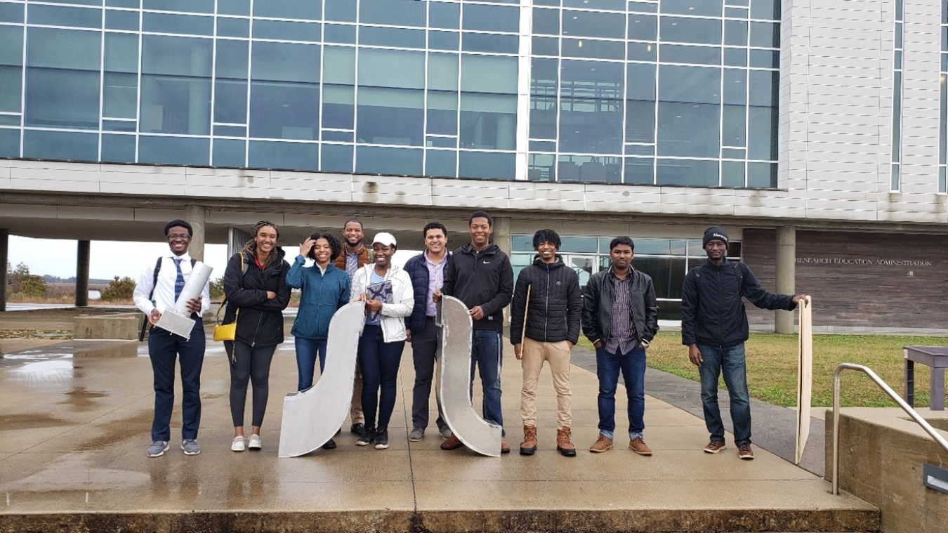 Ten people standing outside a building.