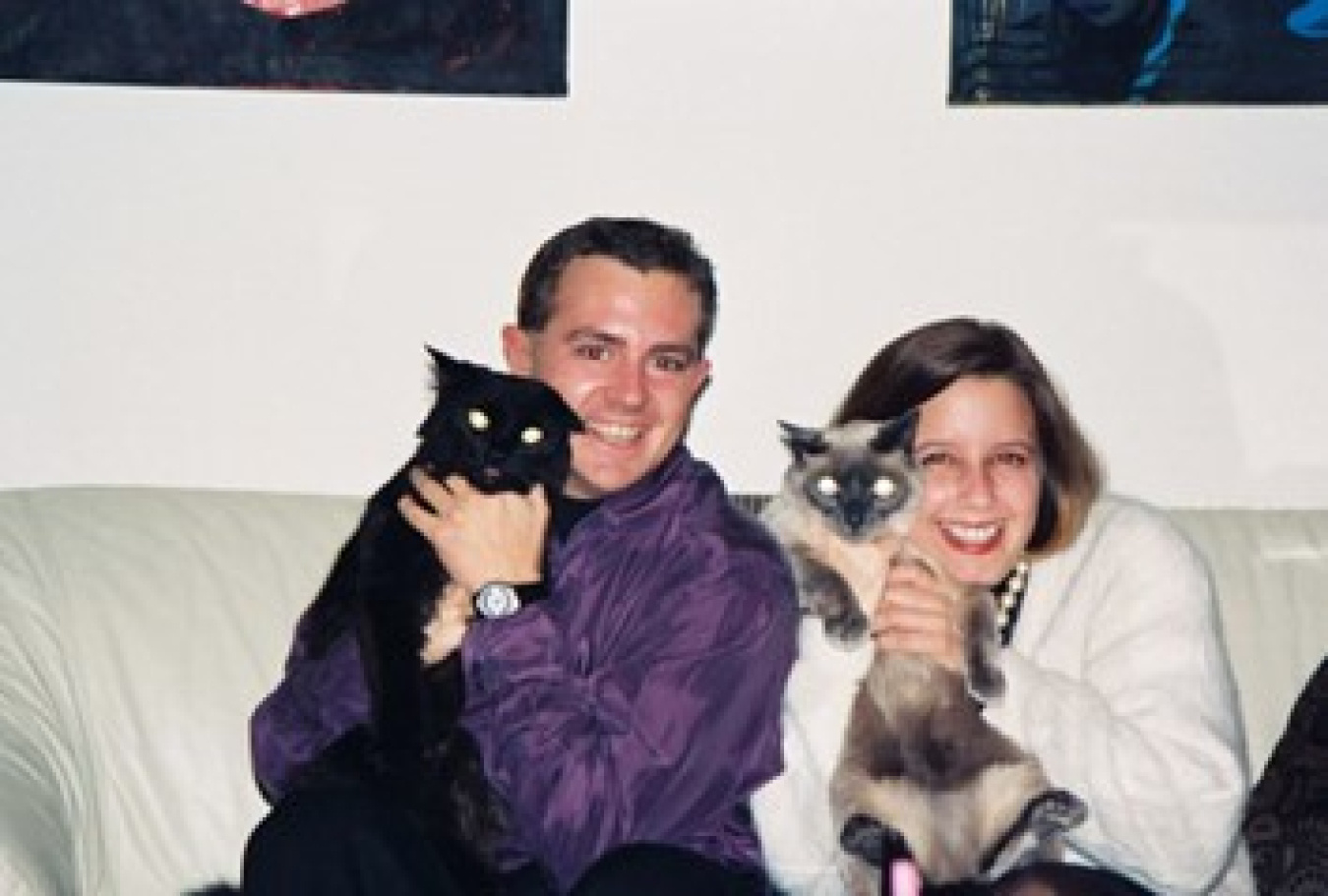 Paul and his friend Carrie sitting on a sofa holding cats.