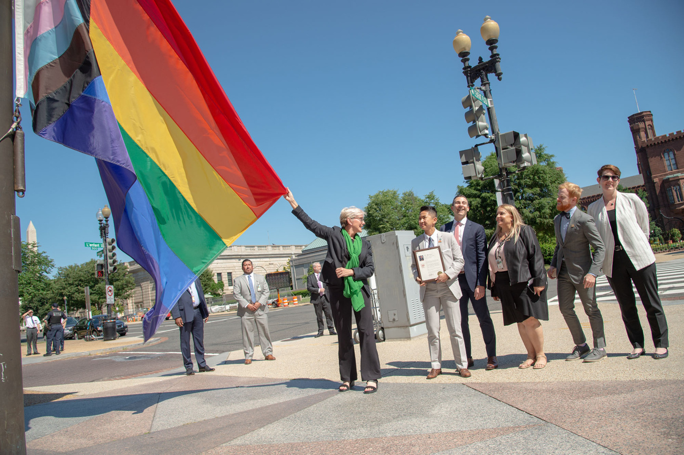 Secretary Granholm raises Progress flag.