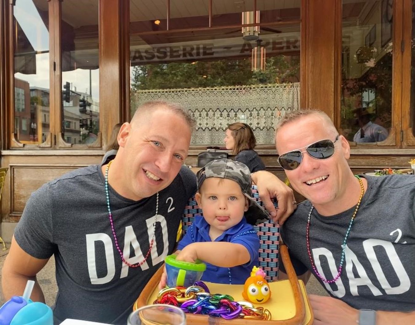 Jason with his husband and son at Pride 2022.