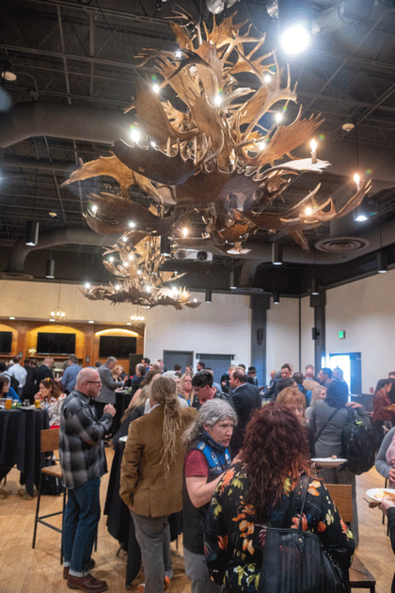 Conference goers interacting with one another in a conference hall.