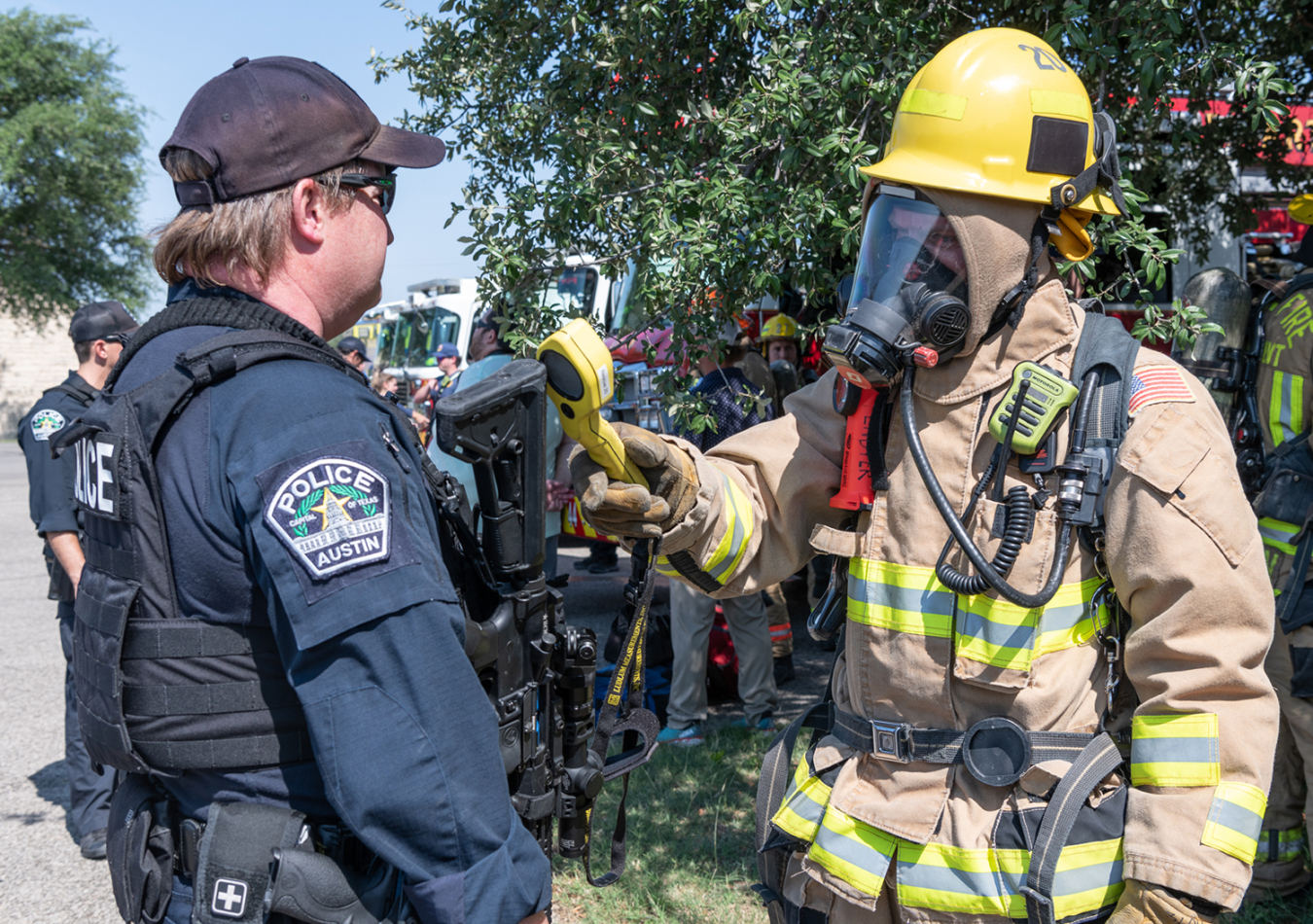 A member of the Austin Fire Department checks an Austin Police Department officer for radiological contamination using a handheld detector. 