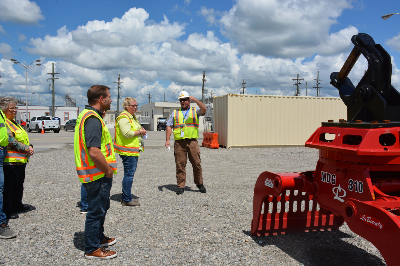 Mike Furner, far right, Fluor-BWXT Portsmouth director of the X-326 uranium process building demolition project, points out a large grappling apparatus used to load X-326 debris into trucks so it can be hauled to the site’s On-Site Waste Disposal Facility for permanent placement.
