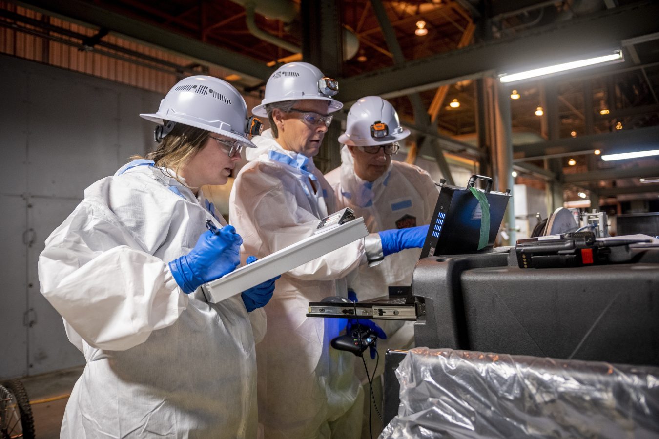 From left, Four Rivers Nuclear Partnership employees Emily Coriell, Kevin Fortner and Joel Grimes evaluate data captured using the robot pipe crawler’s camera and sodium iodide detector system at the Paducah Site.
