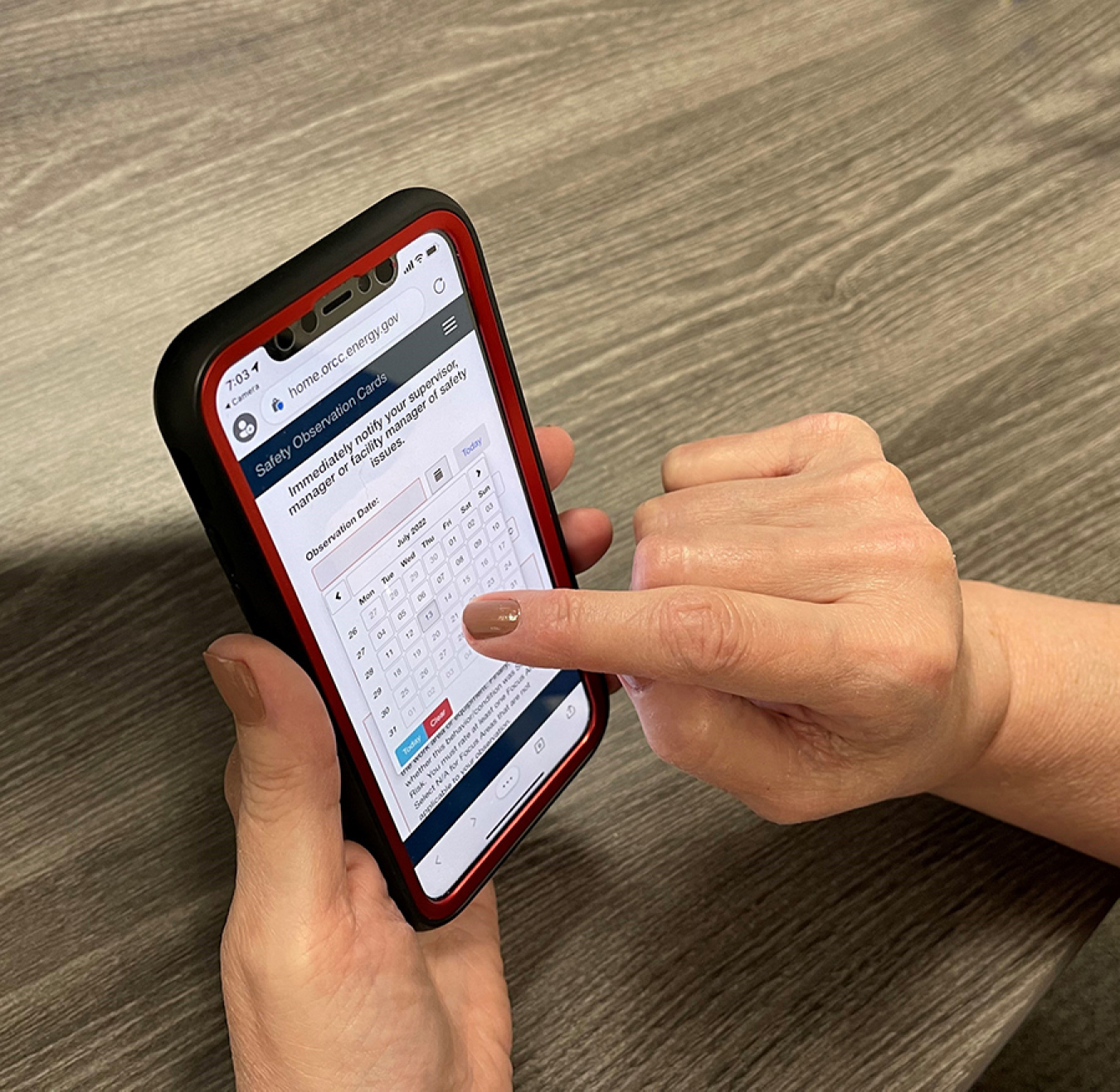 A worker submits a safety observation on a new digital interface that allows workers to report potential safety hazards using their mobile phones at Oak Ridge.