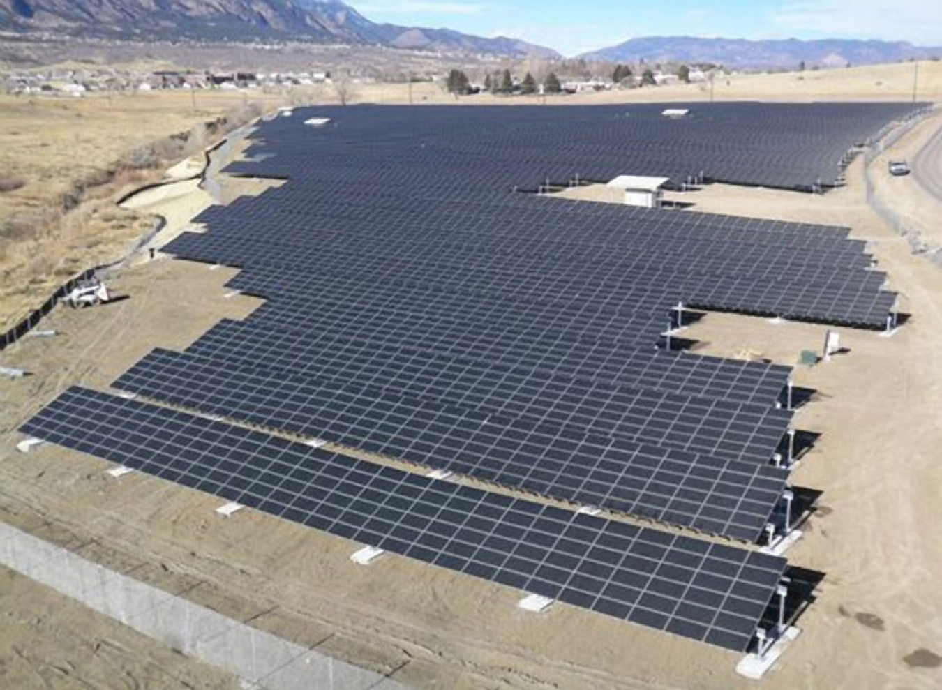 A view of a large solar photovoltaic array in an arid field.