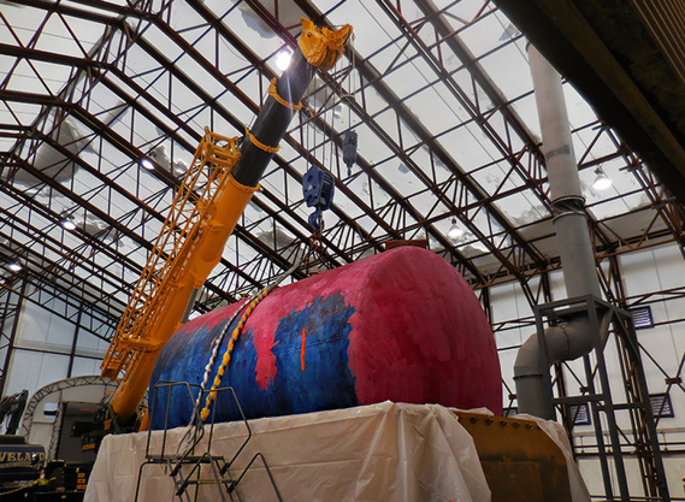 The last of seven tanks in the tank vault at the Separations Process Research Unit is hoisted for placement in a made-to-order shipping container.